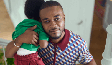 man houdt kind op schouder