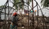 Neema Bihira, een bewoner van het vluchtelingenkamp Mugunga, demonteert het frame van haar onderkomen voordat ze zich klaarmaakt om terug te keren naar haar geboortedorp Shasha.