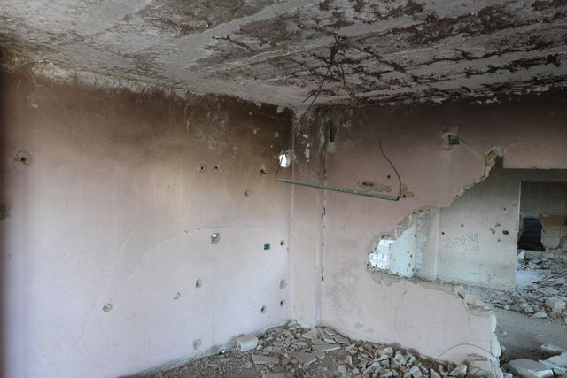 In een gebouw in het ‘niemandsland’ van Tadamon hangt een metalen staaf aan het plafond. 