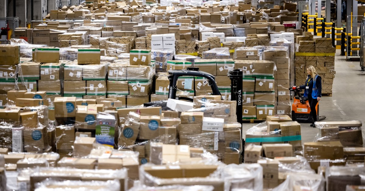 Medewerkers laden pakketten in een sorteercentrum van bezorgdienst DHL