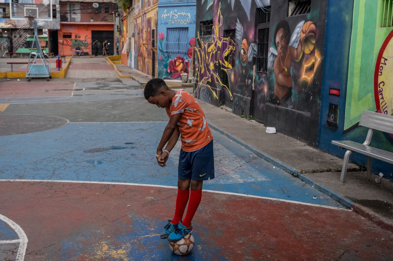 Een jongen speelt met een voetbal in de sloppenwijk San Agustín in Caracas, 2 december.
