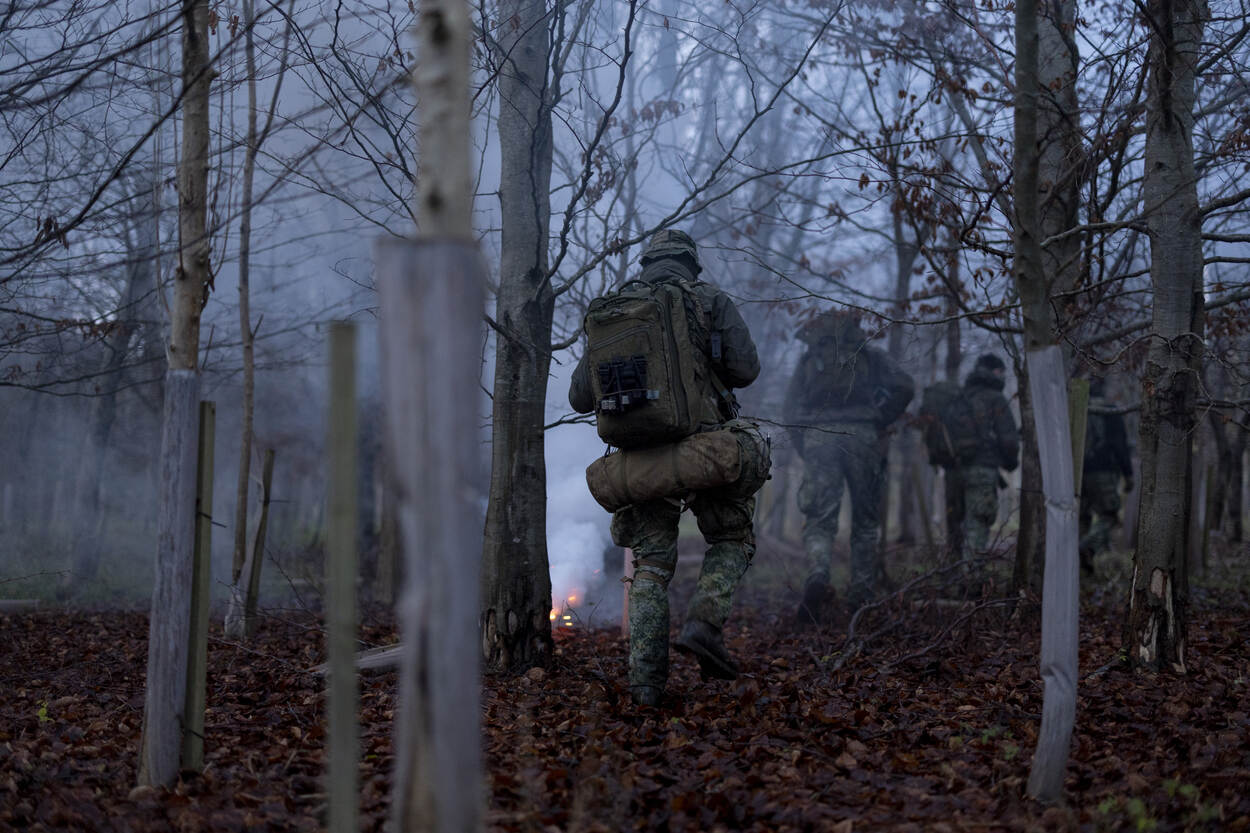 Mariniers lopen in de mist door het bos.