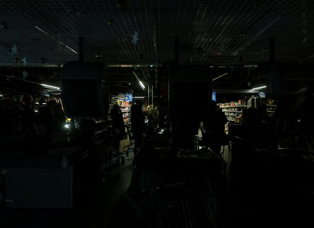 Mensen in een supermarkt zonder elektriciteit tijdens een stroomstoring nadat cruciale civiele infrastructuur werd getroffen door recente Russische raket- en droneaanvallen, 13 december 2025.