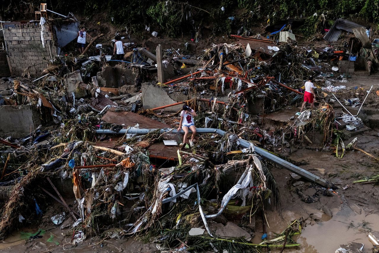 Een vrouw zit op 5 november op een omgewaaide paal, tussen de restanten van verschillende bouwwerken in Talisay, een plaatsje op het Filipijnse eiland Cebu. De schade werd aangericht door tyfoon Kalmaegi, een storm die zo’n tweehonderd levens eiste. De Filippijnen zijn dit jaar door meer dan twintig tropische stormen getroffen, van uiteenlopende kracht.