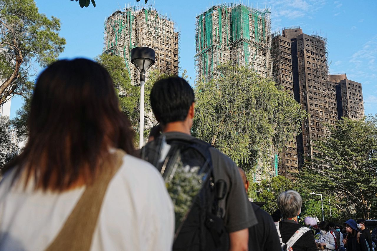 Hongkongers staan dit weekend in lange rijen om bloemen te leggen bij een spontaan ontstane gedenkplaats in een plantsoen vlak bij de getroffen flats.