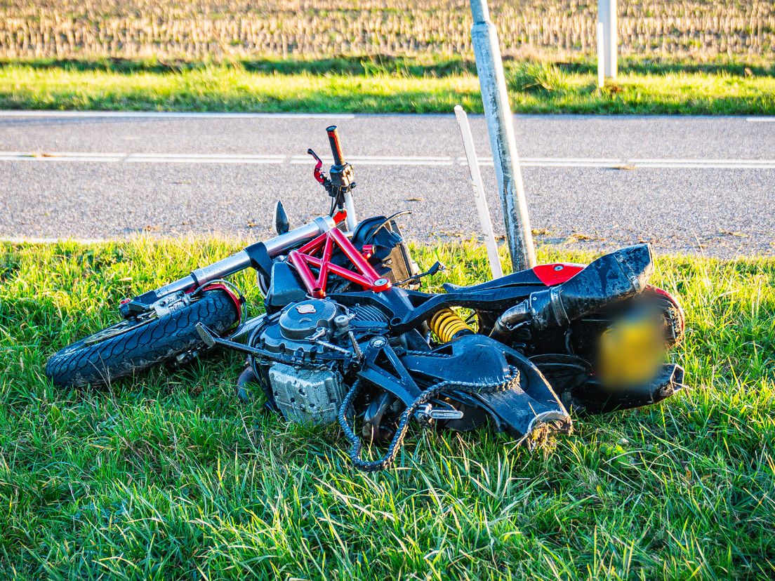 De motor is behoorlijk beschadigd in het gras terechtgekomen en mist een achterwiel dat verderop ligt.