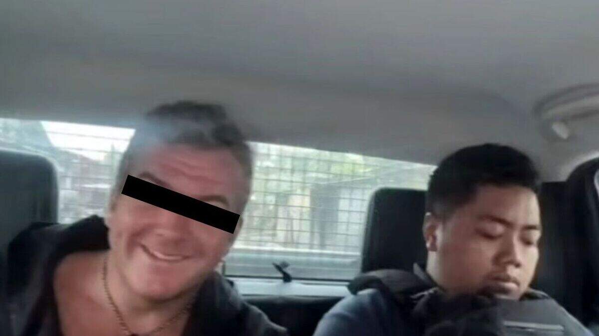 De 41-jarige beschonken Nederlander H. is vrolijk als hij door agente nnaar het politiebureau wordt gebracht.