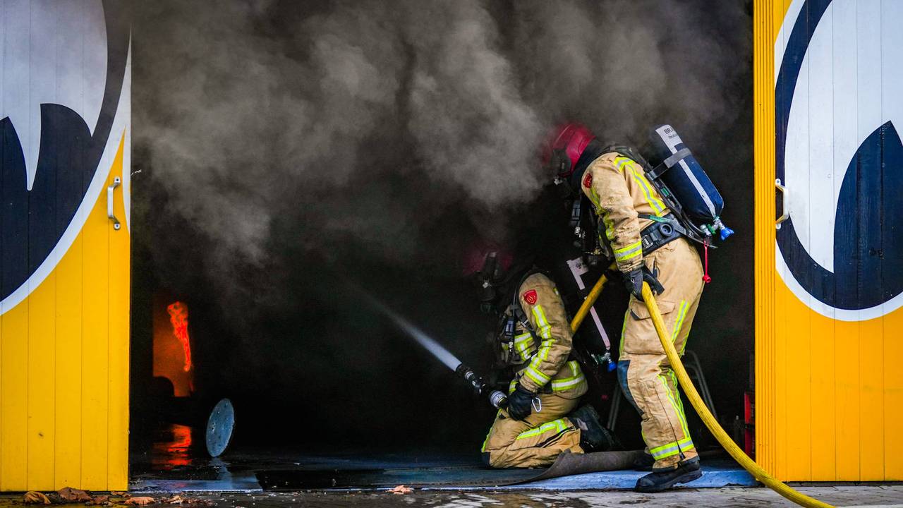 Brandweer bestrijdt het vuur in autobedrijf (foto: Persbureau Heitink)