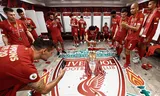 Spelers van Liverpool vieren in de kleedkamer het  winnen van de Premier league in de zomer van 2020. Foto Getty Images