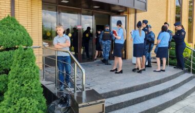 Politieagentes in uniform bij een groot, modern gebouw waarin een baptistengemeente samenkwam.