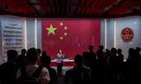 Een gids spreekt bezoekers toe voor de Chinese nationale vlag en het embleem in de National Security Exhibition Gallery, voorafgaand aan de vijfde verjaardag van de nationale veiligheidswet in Hongkong, China, op 20 juni 2025.