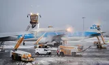 Vliegtuigen worden ijsvrij gemaakt op Schiphol - een tijdrovende procedure.