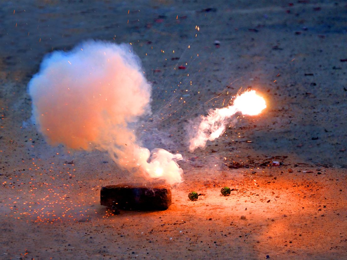 Het vuurwerk werd vanuit een woning naar de agente gegooid.