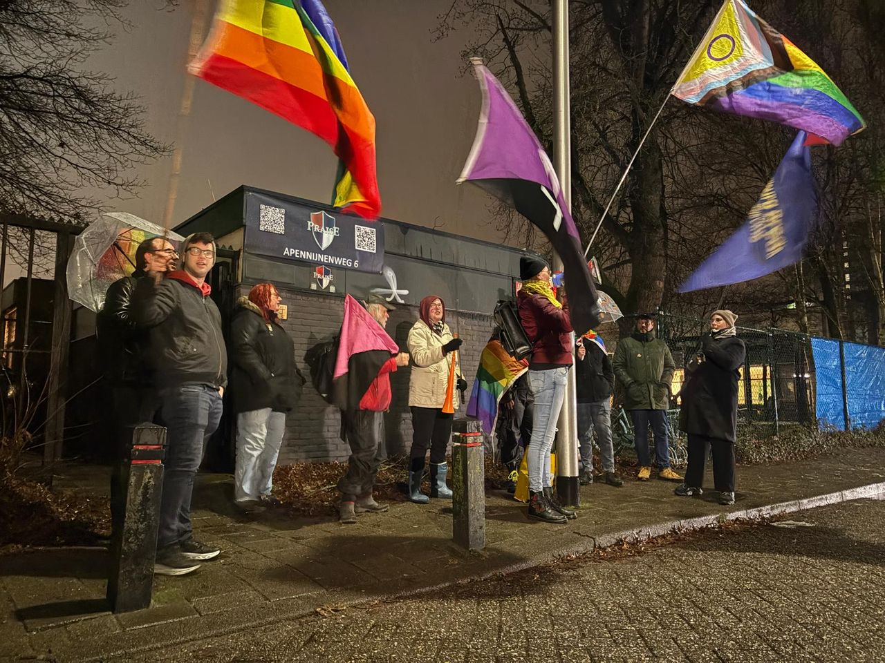 Demonstranten zwaaien met vlaggen voor de ingang van de kerk.