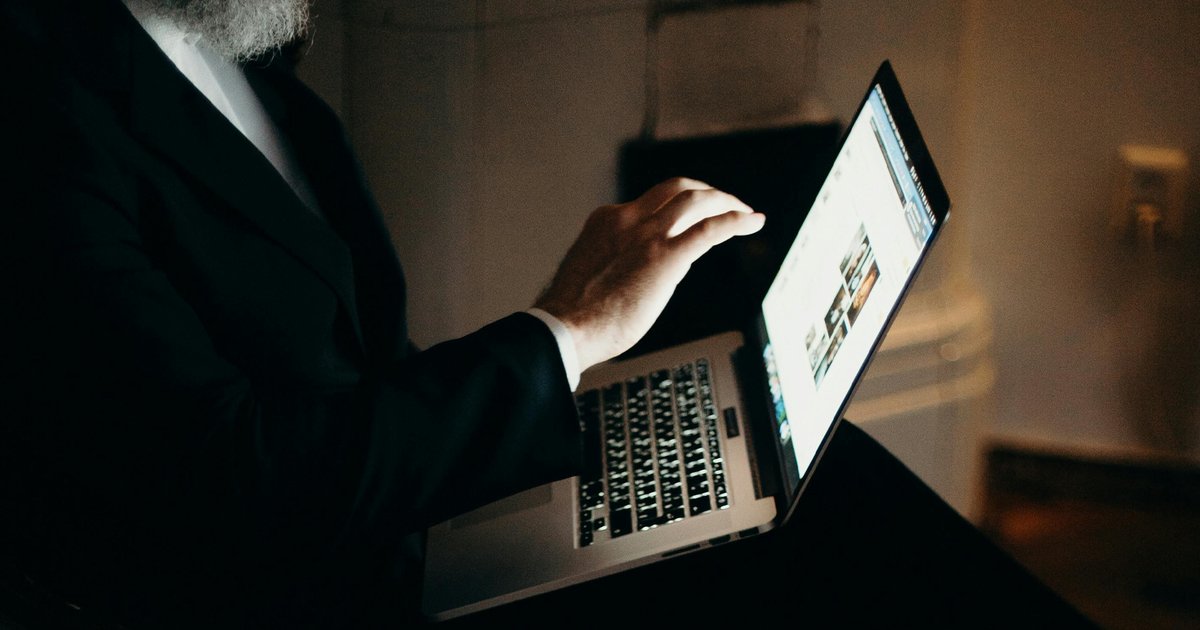 Beeld ter illustratie: man die op laptop deepfakes genereert