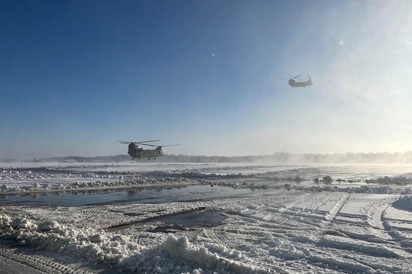 Helikopters boven een sneeuwlandschap.