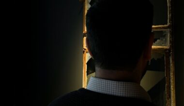 Silhouet van een man met donker haar. Op de achtergrond een kapotgeschoten raam.