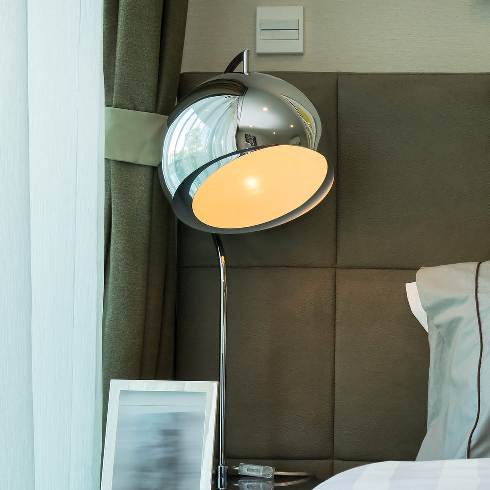 metal desk lamp and grey pillow on bed metal desk lamp and grey pillow on bed