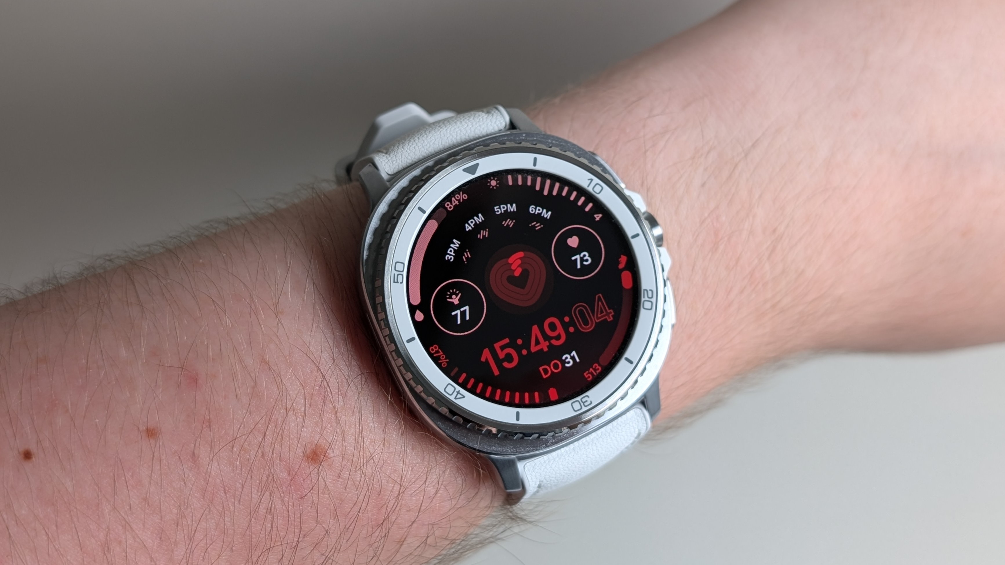 Samsung Galaxy Watch 8 Classic i hvitt rundt et håndledd.