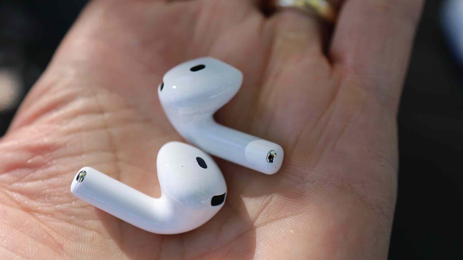 AirPods 4 med aktiv støyreduksjon hviler i en åpen håndflate.
