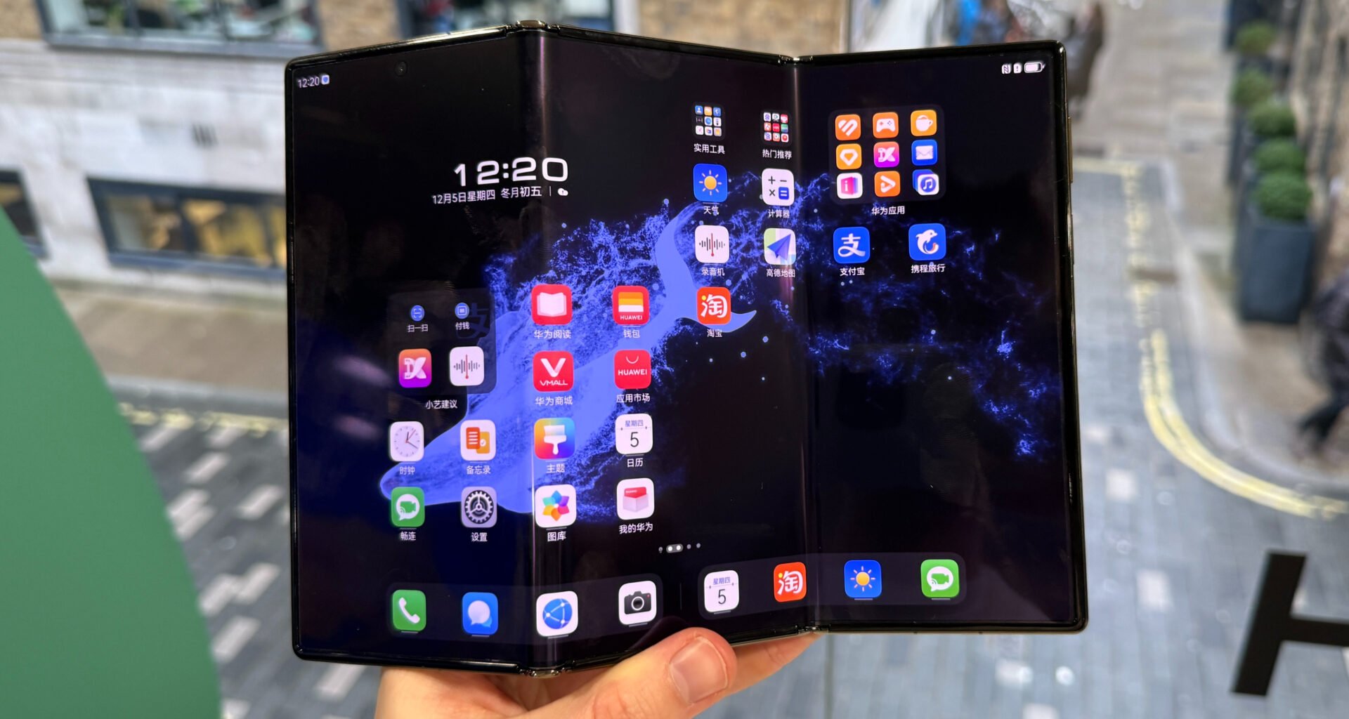 En person holder en Huawei Mate XT.
