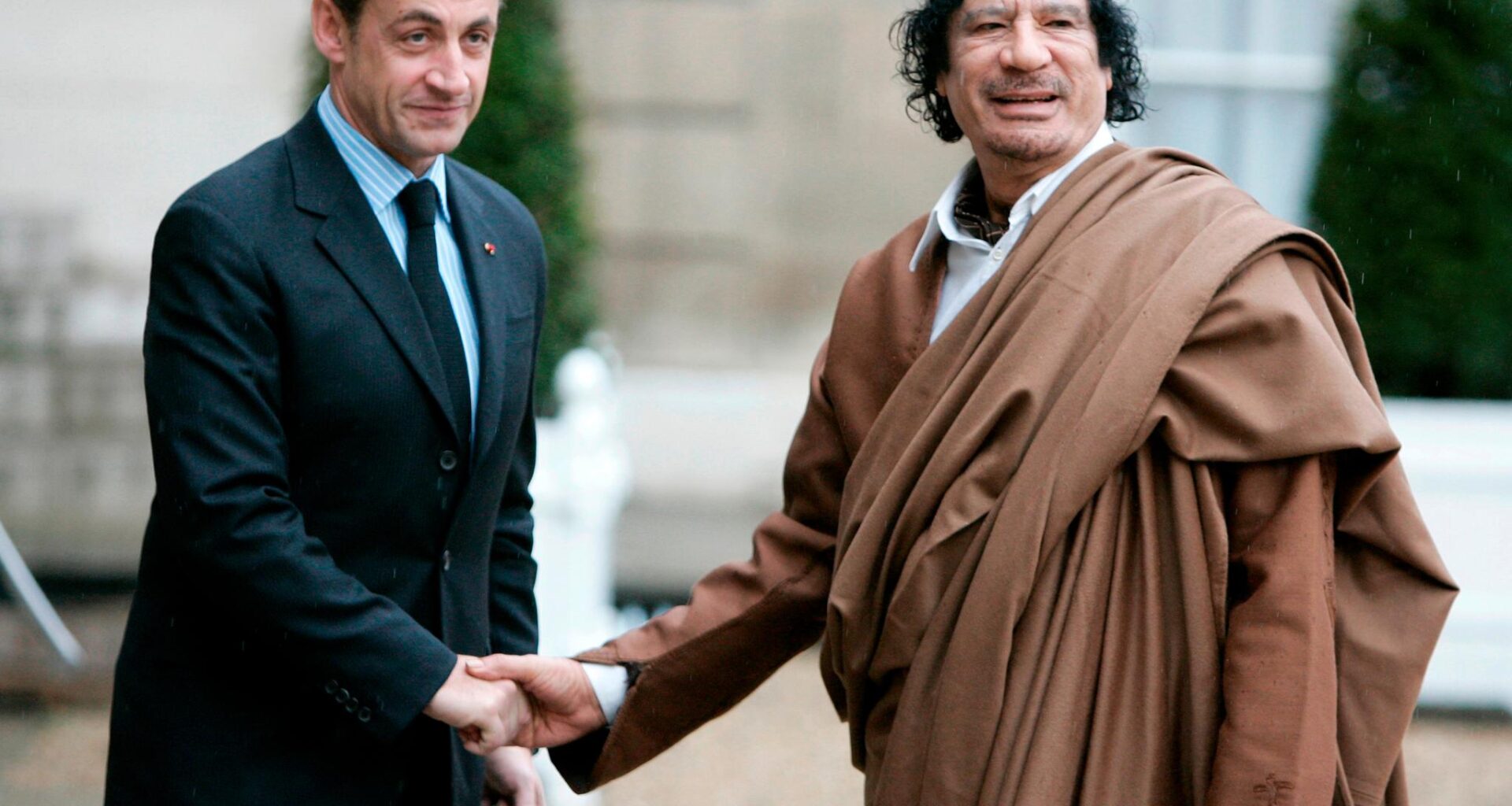 Sarkozy (t.v.) på vei inn i retten med sin kone Carla Bruni-Sarkozy.