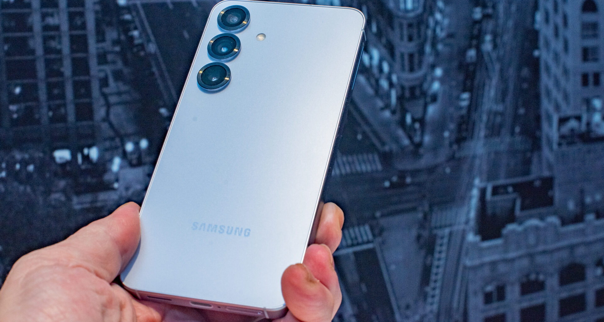 Samsung Galaxy S25 held in hand at an angle to reflect the Samsung logo