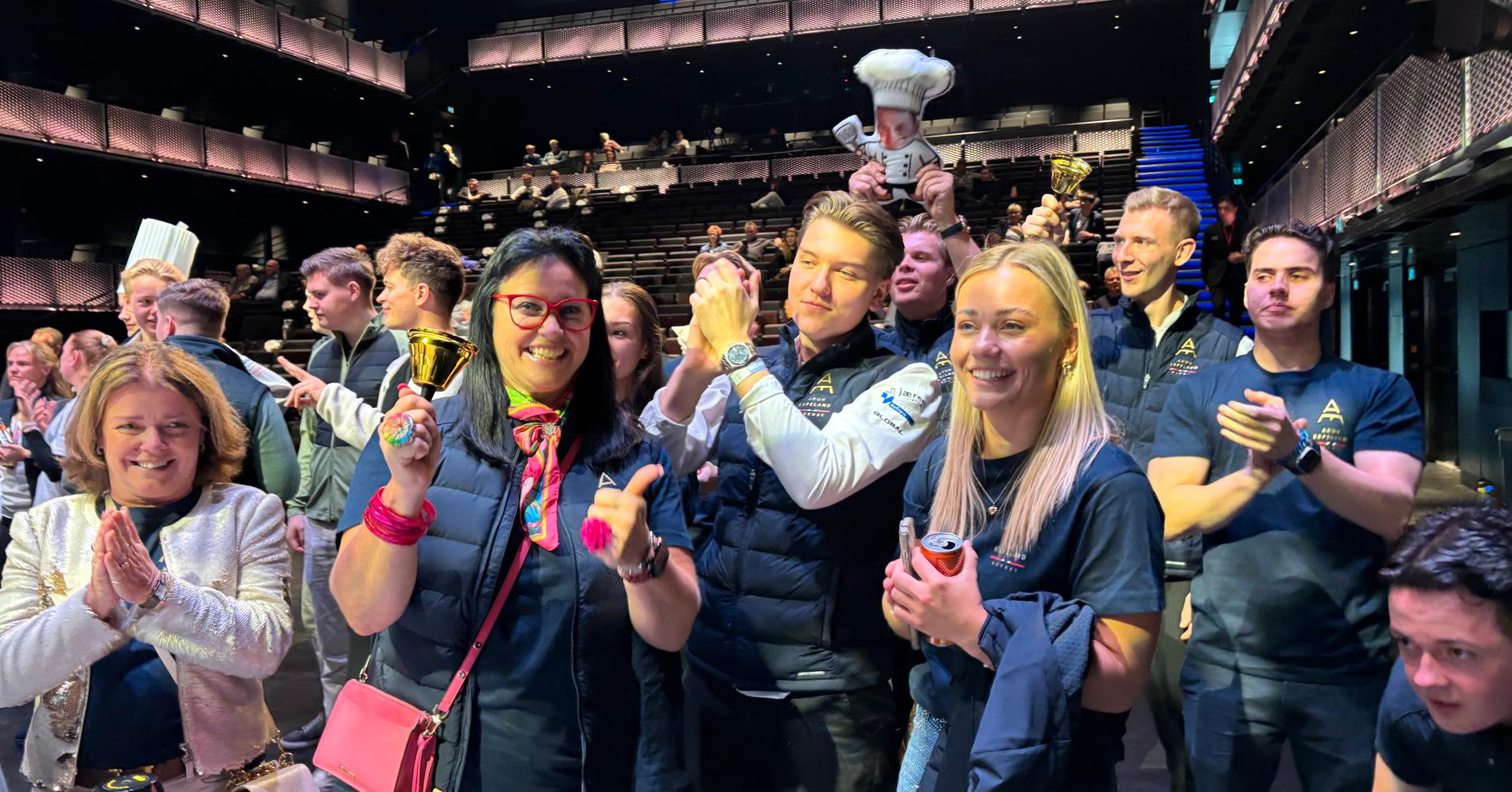 Venner og familie av Aron Espeland holder trøkket oppe med sang og trampeklapp. De tre i midten: Jane Espeland (mor), Andreas Enger Fjellheim (Team Espeland) og Martine Espeland (søster og Team Espeland).