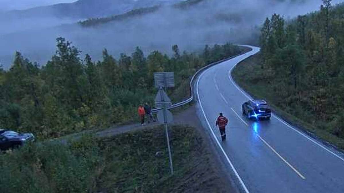 En sivil politibil står parkert på siden av veien mens en person kommer gående fra bilen.