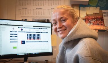 en person som smiler foran en dataskjerm