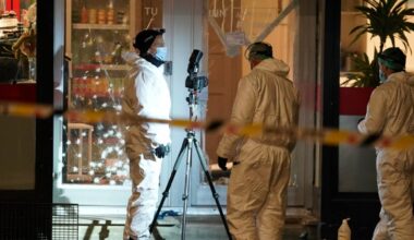 en gruppe menn i hvite uniformer som står utenfor en butikk