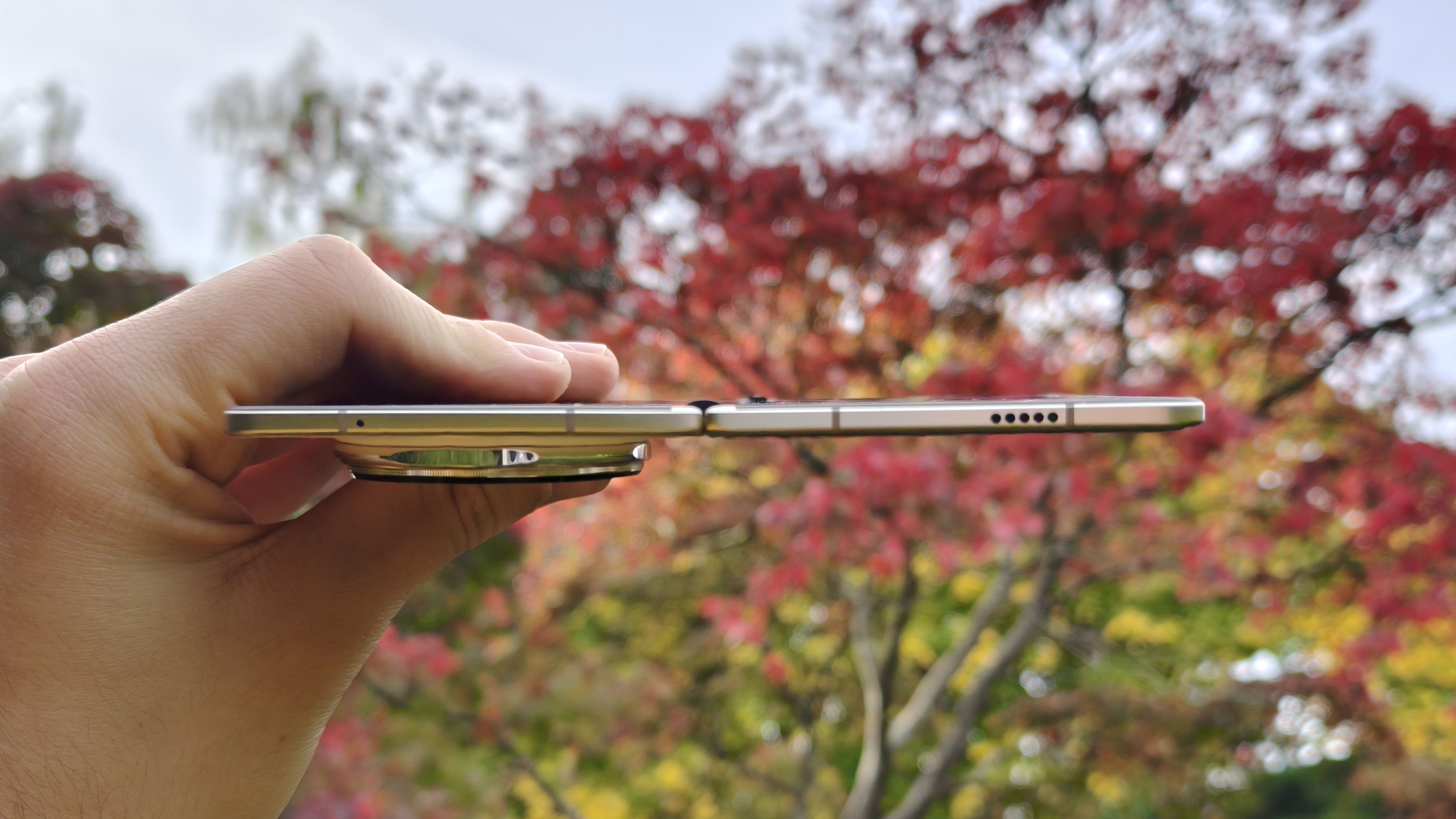 Honor Magic V5 vises fra siden, foran r&oslash;de, gule og gr&oslash;nne h&oslash;sttr&aelig;r.