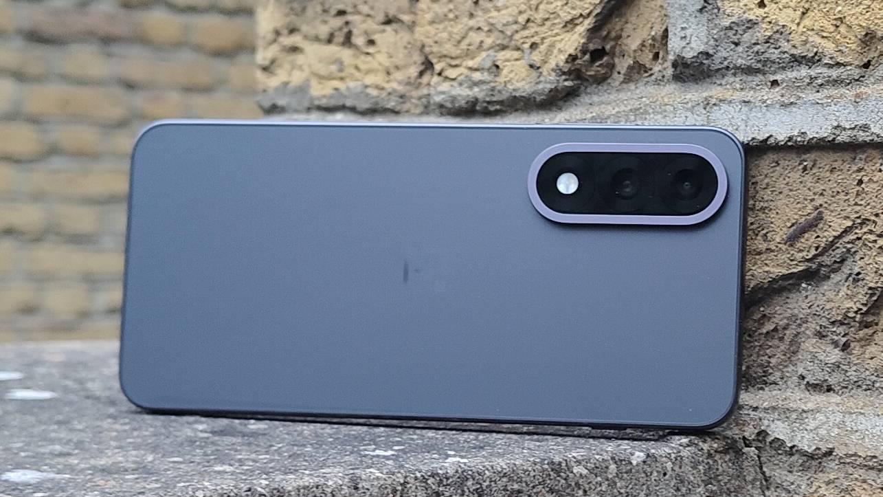 OnePlus Nord 5 lent mot en teglvegg.