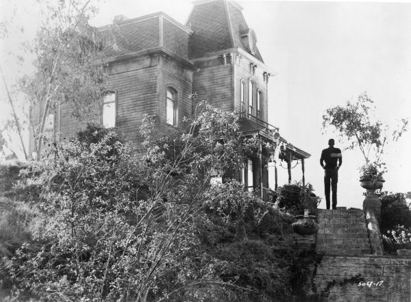 View of actor Anthony Perkins standing beside the Bates Motel in a still from the film, 'Psycho,' directed by Alfred Hitchcock, 1960. (Photo by Paramount Pictures/Courtesy of Getty Images) 