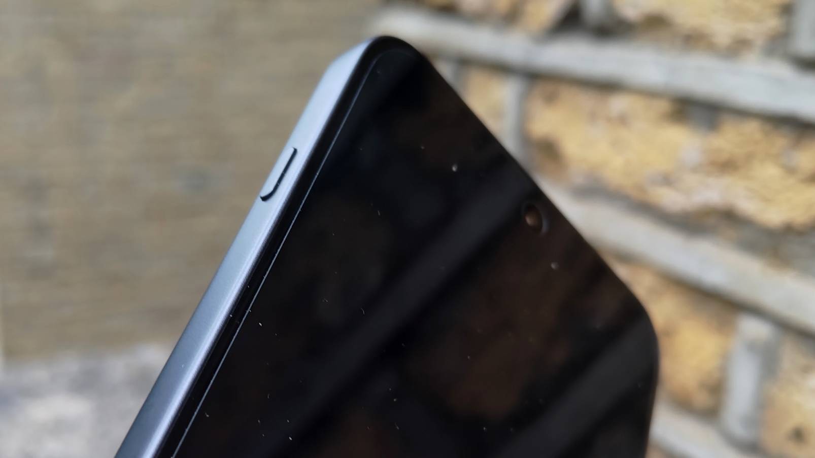 OnePlus Nord 5 lent mot en teglvegg.