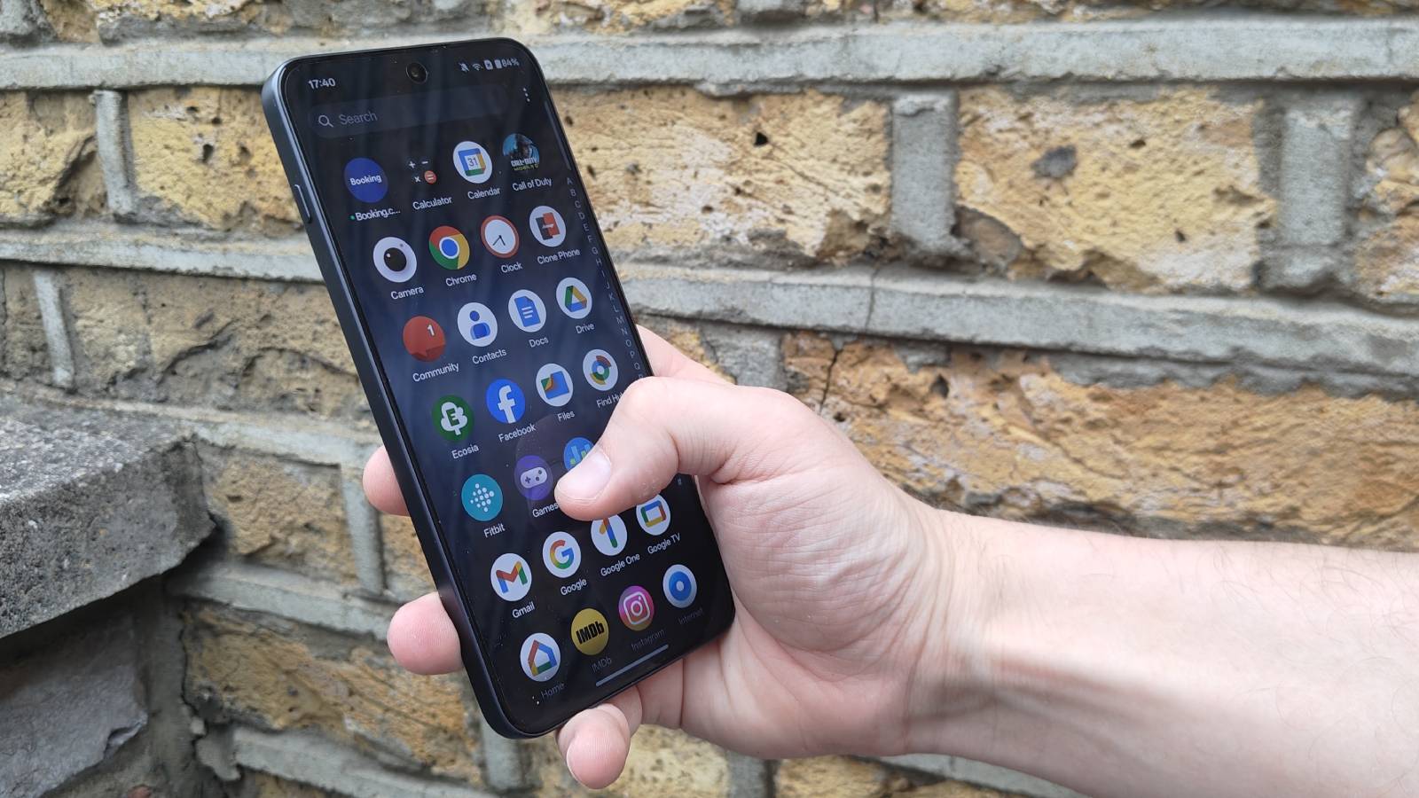 En person blar gjennom appene p&aring; hovedskjermen til en OnePlus Nord 5.