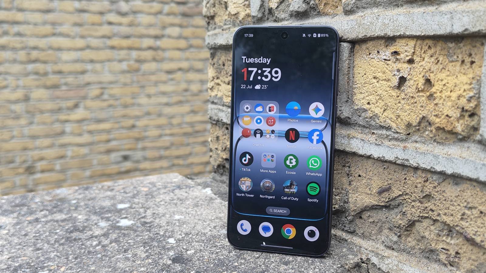 OnePlus Nord 5 lent mot en teglvegg.
