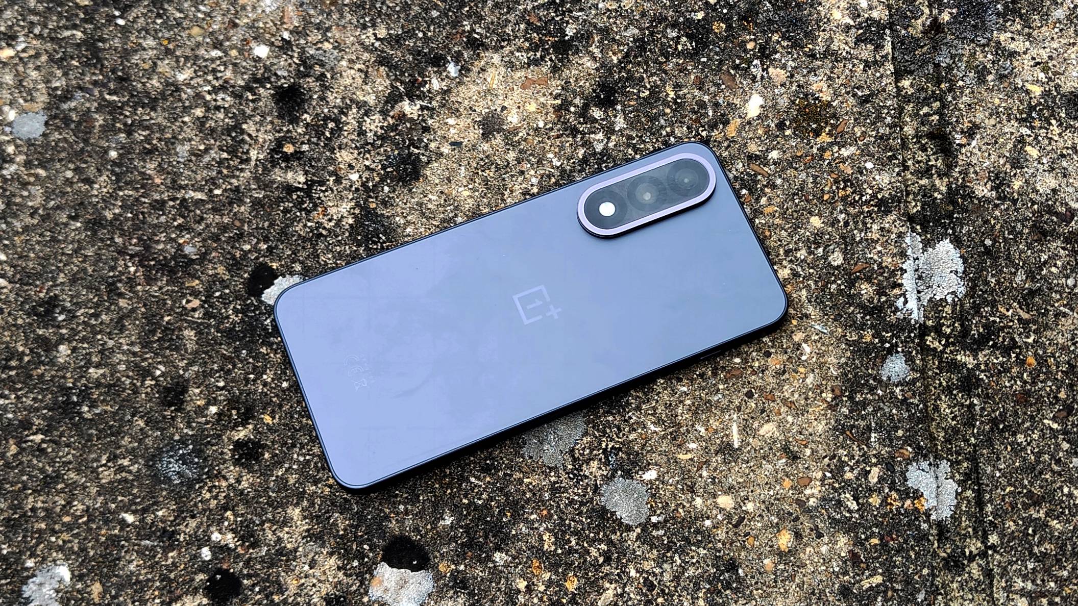 OnePlus Nord 5 ligger p&aring; en teglmur.