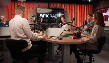 Seks mennesker rundt et radiostudiobord, de ler. Programleder Cille Biermann i midten