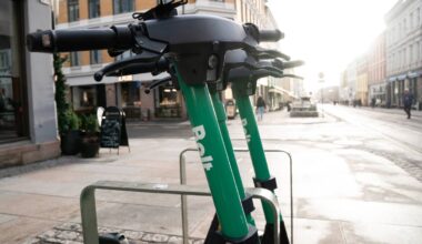 En grønn elsparkesykkel parkert på fortauet