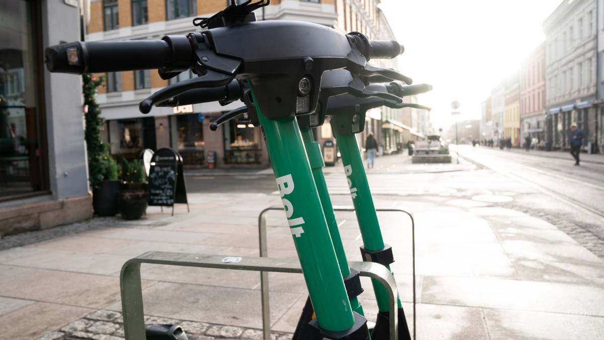 En grønn elsparkesykkel parkert på fortauet