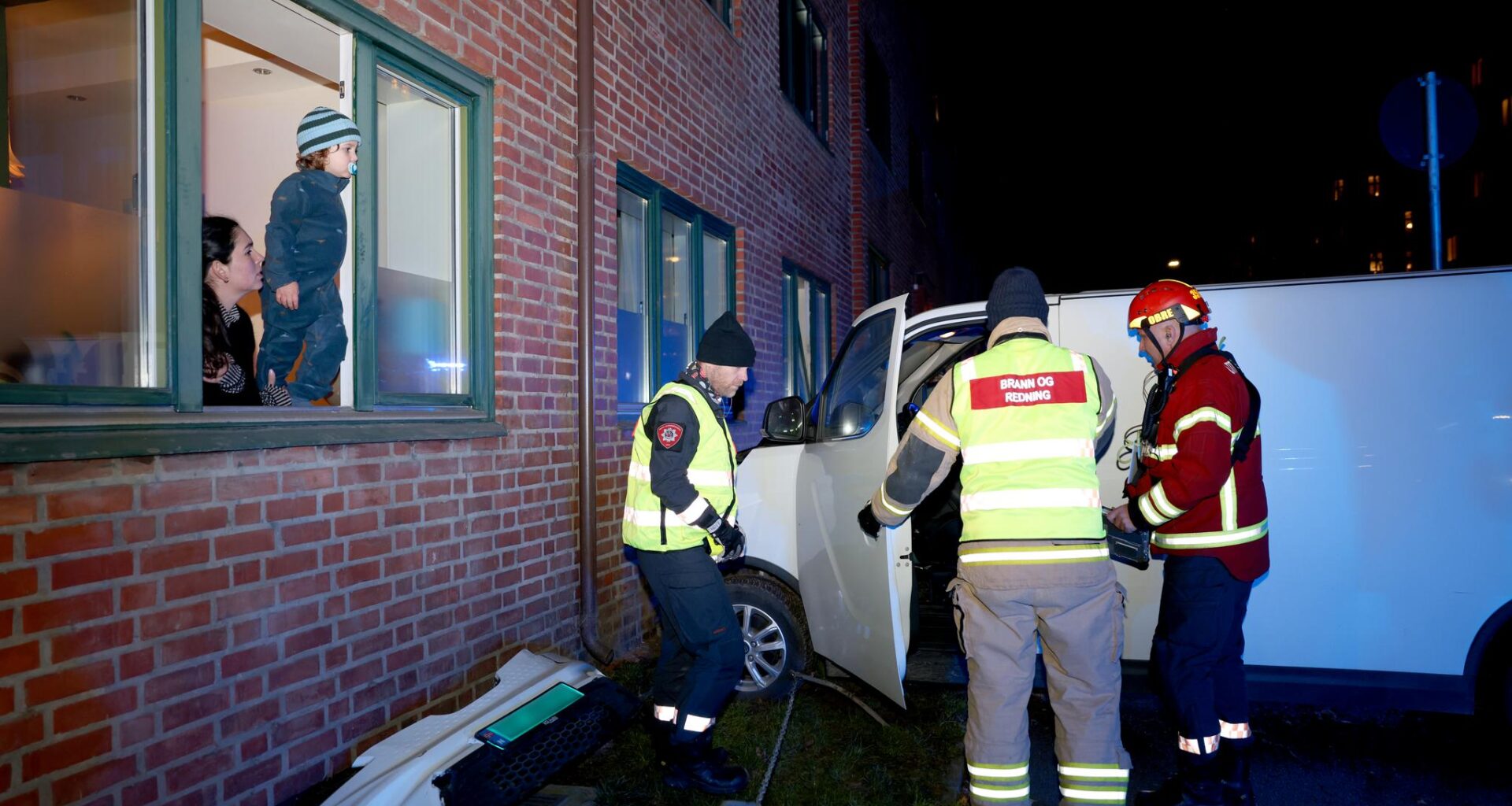 Samira Alavinasab-Jara og sønnen Gabriel Bomgren følger redningsmannskapet mens bilen deres blir løftet bort fra murveggen.