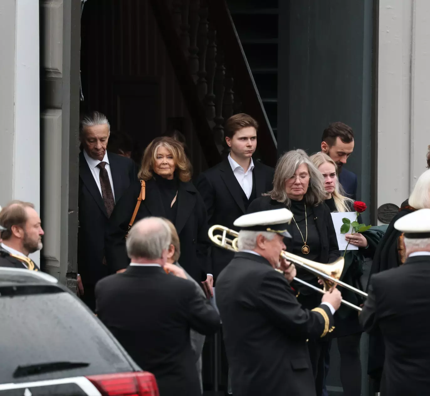 ET SISTE FARVEL: Wenche Myhre på vei ut av kirken med ektemannen Anders Eljas ved sin side. I forgrunnen står deler av Kampen Janitsjarorkester, som hedret Reidar. Foto: Andreas Fadum / Se og Hør
