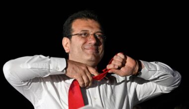 Valgvinner Ekrem Imamoglu tar av seg slipset før han taler.