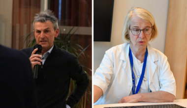 En mann holder en mikrofon og en kvinne sitter ved en pult