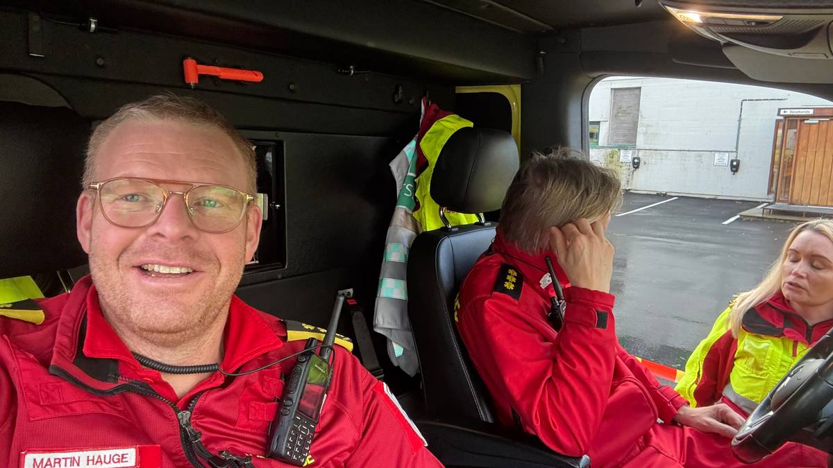 En mann i ambulanseuniform sitter inne i en ambulanse.