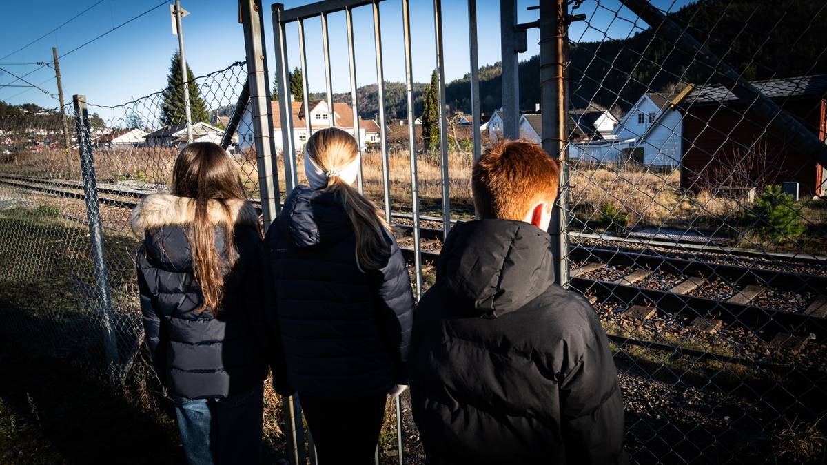 En gruppe barn som står utenfor noen togskinner.