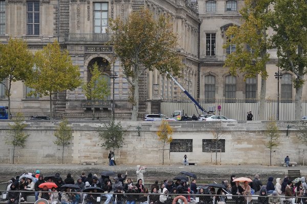 Police officers, background, look for clues by a basket lift used by thieves Sunday, Oct. 19, 2025 at the Louvre museum in Paris. (AP Photo/Thibault Camus)