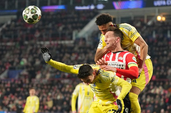PSV's Luuk de Jong, centre, challenges for the ball with Juventus' Andrea Cambiaso, left, and Juventus' Lloyd Kelly during the Champions League playoff second leg soccer match between PSV and Juventus at Phillips Stadium in Eindhoven, Netherlands, Wednesday, Feb.19, 2025. (AP Photo/Peter Dejong)
