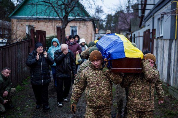 An honor guard carries the coffin of Ruslan Zhygunov, a Ukrainian serviceman, who was killed at the frontline near Rusyn Yar village, during his funeral ceremony in Hostomel, Ukraine, on Saturday, Nov. 22, 2025. (AP Photo/Evgeniy Maloletka)